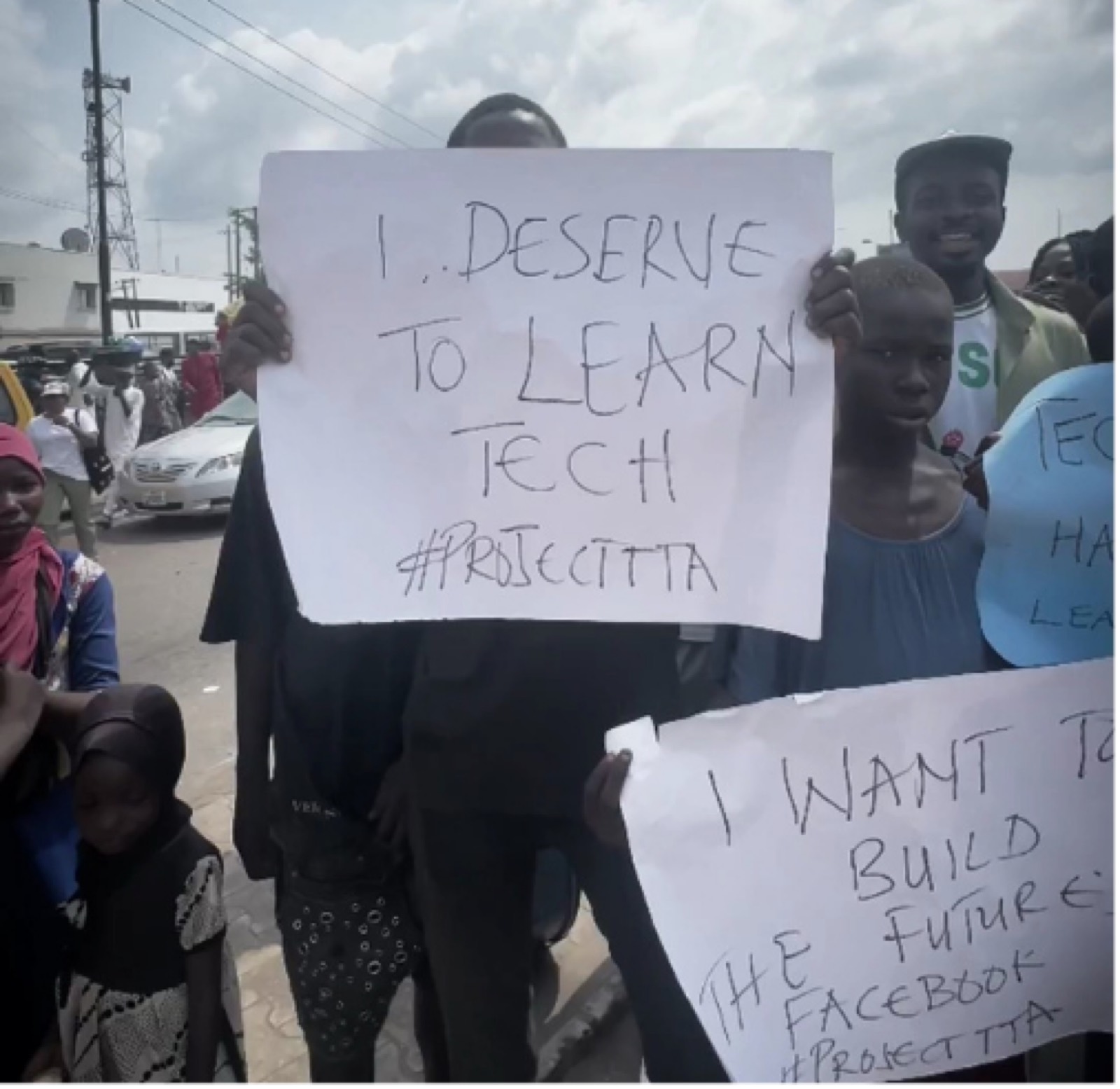Children on Ring Road, Benin City holding signs reading 'I deserve to learn tech'